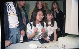Open House 1998; two girls in front of computer with students standing behind them