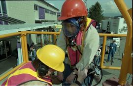 Open House 1998; woman in safety gear and line is lowered into confined space with assistance by ...