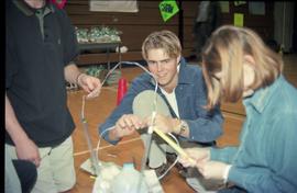 Open House 1998; student connecting wires together to make arch in the gym