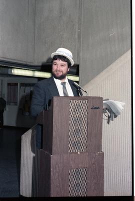 Open House 1986; man with open house hat behind podium