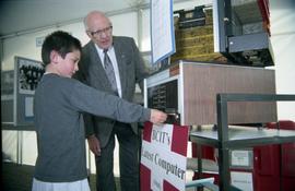 Open House 1998; boy touches BCIT's latest computer (1965) display as older man looks on [photogr...