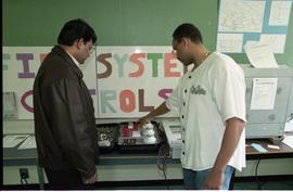 Open House 1998; student pointing to first system alarm display to man [photograph 2 of 4]