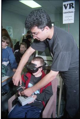 Open House 1998; man helping boy with joystick adjustment