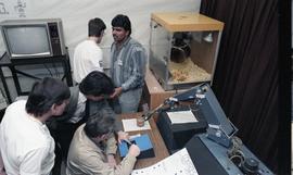 Open House 1986; group enjoying robotics demonstration with popcorn machine in background