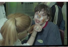 Open House 1998; child getting rainbow and clouds drawn on their face [photograph 2 of 3]