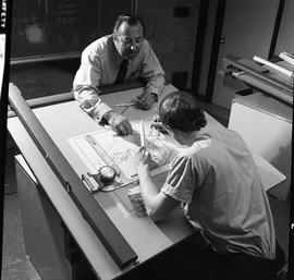 BC Vocational School drafting course ; student working on a diagram using a compass ; instructor ...