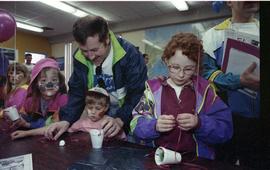 Open house 1992; children with fathers making crafts with fake grass and cups