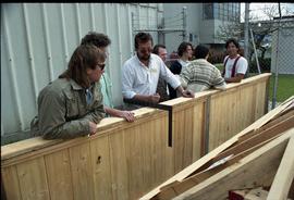 Open house 1992; man using L square and explain to class in front of wooden construction