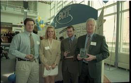 Open House 1998; group of four hold up glass rewards given by BCIT [photograph 1 of 2]