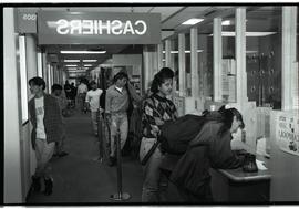 Communications Relations Opening Day 1991;  student stares at camera while waiting in cashier lin...