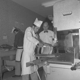 Meat cutting, 1968;  a student cutting ribs and the instructor watching ; students working in bac...