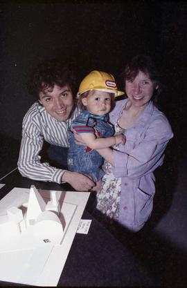 Open House 1992; couple posing with toddler in front of  guest house model [photograph 1 of 2]