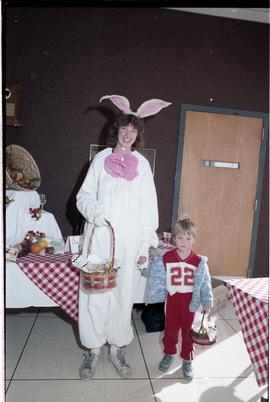Open House 1986; woman dressed as rabbit with child in front of tables [1 of 2 photographs]