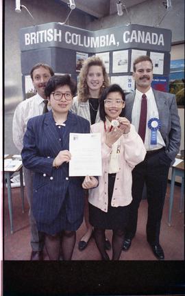 Open house 1992; group of men and women stand in front of display with awards