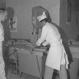 Meat cutting, 1968;  student holding a piece of meat and instructor watching