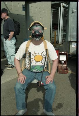 Open House 1998; man sitting with gas mask unfitted on