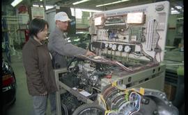Open House 1998; two people in front of Toyota technical educational program display of engine an...