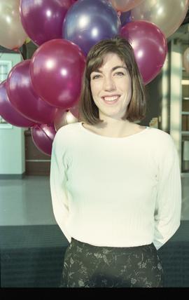 Open house 1995; woman smiling in front of balloons [photograph 1 of 4]