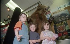 Open House 1998; three girls standing in front of stuffed bear display [photograph 2 of 3]