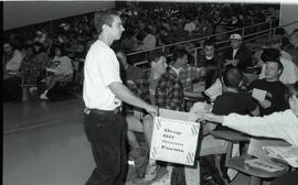 Communications Relations Opening Day 1991; man holding out drop off shrinerama forms box out to s...