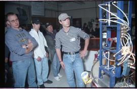 Open House 1998; men in baseball caps surveying machine