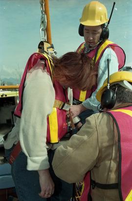 Open House 1998; woman being helped out of safety gear after demo