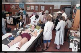 Open House 1986; various medical displays with volunteer displaying EEG in lab  [2 of 3 photographs]