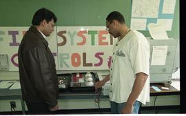 Open House 1998; student pointing to first system alarm display to man [photograph 3 of 4]