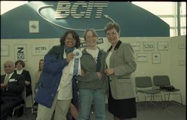 Open House 1998; two women pose with woman in suit while holding 1st place ribbon [photograph 1 o...