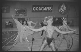 Staff (?) in costumes doing aerobics in a gymnasium [14 of 15 photographs]