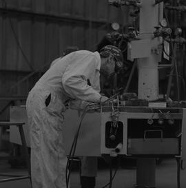 Welding, 1968; man wearing protective goggles welding ; welding equipment in background