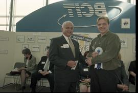 Open House 1998; student holding 1st place ribbon shaking hands with older man in suit [photograp...