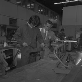 Sheet metal, 1968; instructor observing a student working on a piece of metal in a vice ; student...