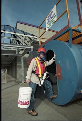 Open House 1998; person in safety vest and gas mask stands in front of confined space demonstrati...