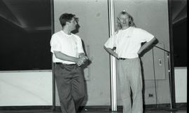 Communications Relations Opening Day 1991; two men in orientation t-shirts talking