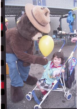 Open House 1998; Smokey the Bear giving balloon to child in stroller
