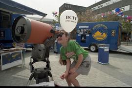 Open house 1992; child squatting and using Schmidt–Cassegrain telescope [photograph 1 of 2]