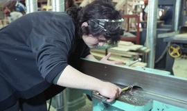 BCIT Women in Trades; carpentry, woman using bench tool (sander?) [2 of 5 photographs]