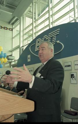 Open House 1998; Peter Legge gestures behind podium on Open House BCIT stage