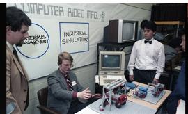 Open House 1986; man explaining computer aided management to group [photograph 1 of 2]