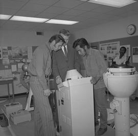 Navigation, 1968; three men looking at a piece of navigation equipment [2 of 2]