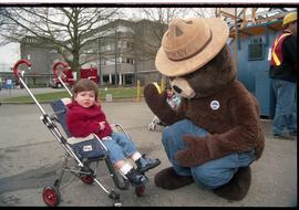 Open House 1998; upset child in stroller looking away from kneeling Smokey the bear [photograph 2...