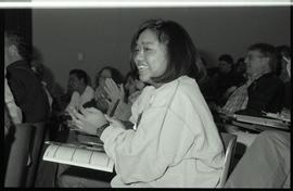 Communications Relations Opening Day 1991; student in lecture seat smiling and clapping with othe...