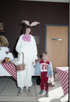 Open House 1986; woman dressed as rabbit with child in front of tables [ 2 of 2 photographs]