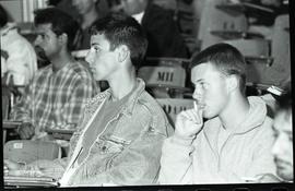 Communications Relations Opening Day 1991; two young men listening with other people in backgroun...