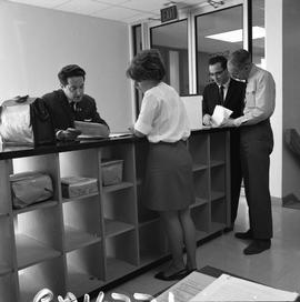 BCVS Graphic arts ; four people standing at a shelf and looking at papers [2 of 3]