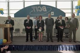 Open House 1998; woman and men on Open House BCIT stage with speaker behind podium on the far lef...