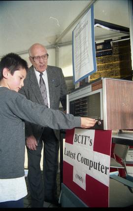 Open House 1998; boy touches BCIT's latest computer (1965) display as older man looks on [photogr...