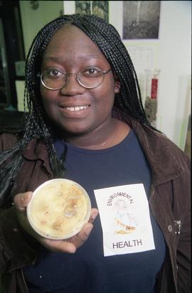 Open House 1998; student holding up bacteria growth in petri dish [photograph 2 of 2]