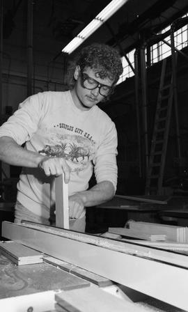 BCIT Carpentry, 1989, man wearing eye protection cutting wood [1 of 7 photographs]